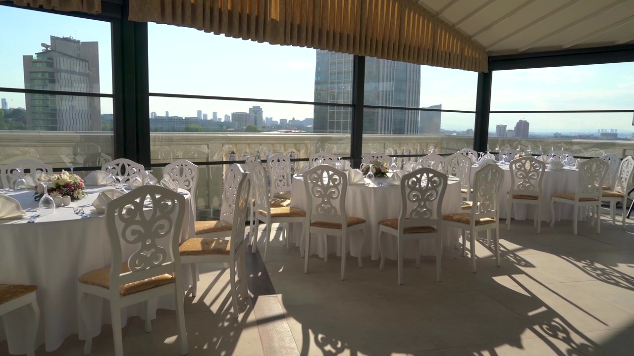 Elegante montaje de salón de banquetes en terraza en la azotea con vista a la ciudad