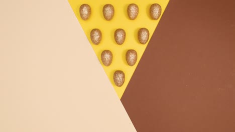 easter golden glamour eggs appear on three colored golden nude background. stop motion flat lay pattern