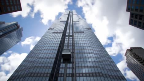a stunning view of a towering skyscraper against a bright blue sky, captured from ground level, showcasing its imposing architecture and modern design features