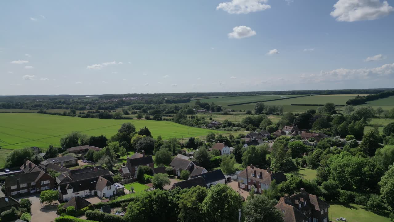 An ascending boom shot of St John the Evangelist church's steeple, rising to reveal the village of Ickham