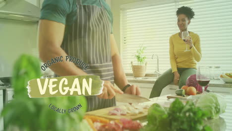 animation of vegan text over diverse couple preparing healthy meal in kitchen