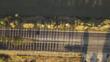 aerial top down shot of car driving on coastal boulevard road beside river in buenos aires during sunny day