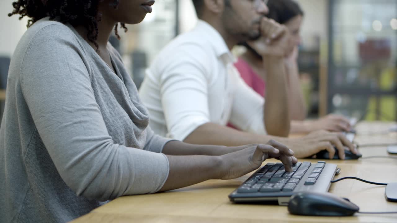 Closeup shot of people sitting at tables and typing