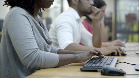 Closeup-shot-of-people-sitting-at-tables-and-typing