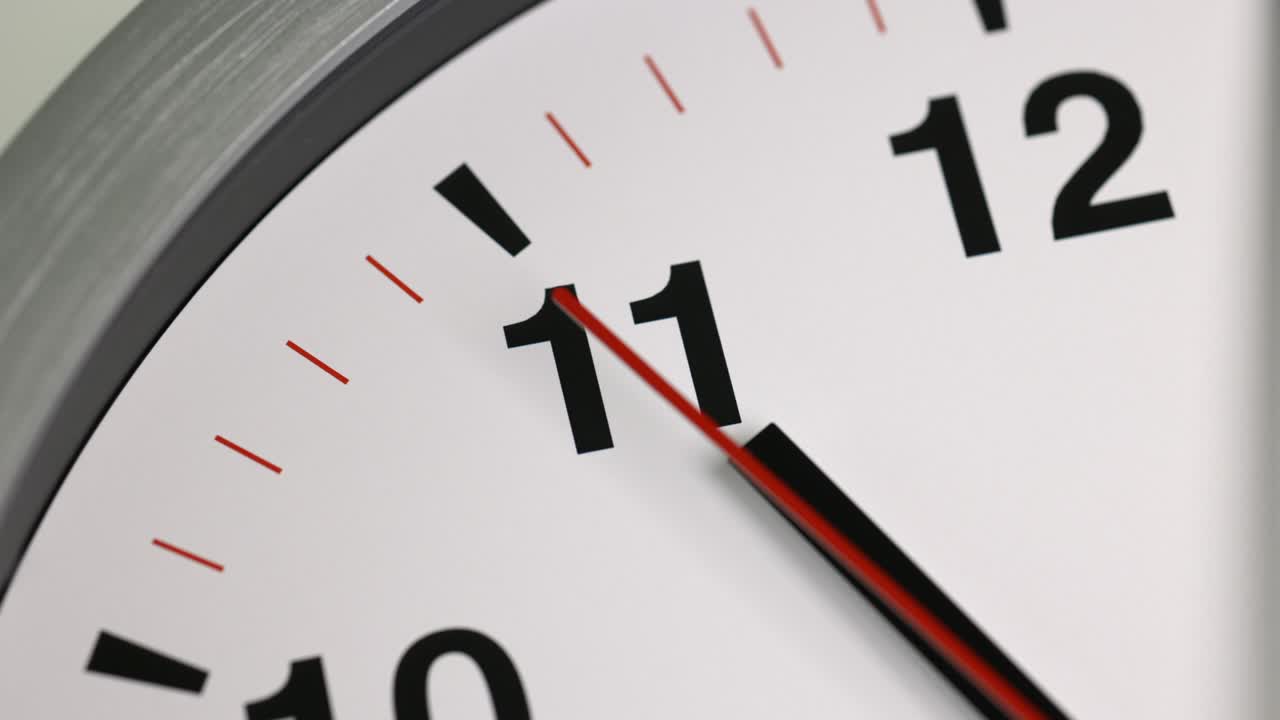 gran reloj de pared blanco fijó la hora para las 11.00 horas. la manija de minutos roja sigue funcionando. película de lapso de tiempo.