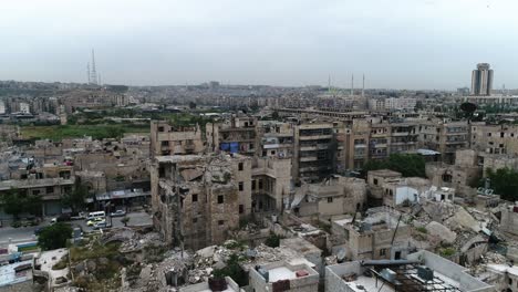 a syrian city from above with cars driving on a road. some of the buildings are still in ruins after the civil war 10 years ago - aerial view with a drone 4k