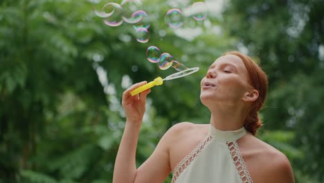 woman blowing bubbles in a park