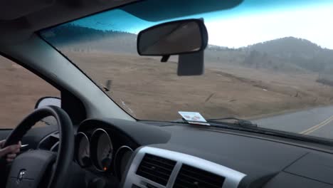 Women-driving-on-country-road-while-raining