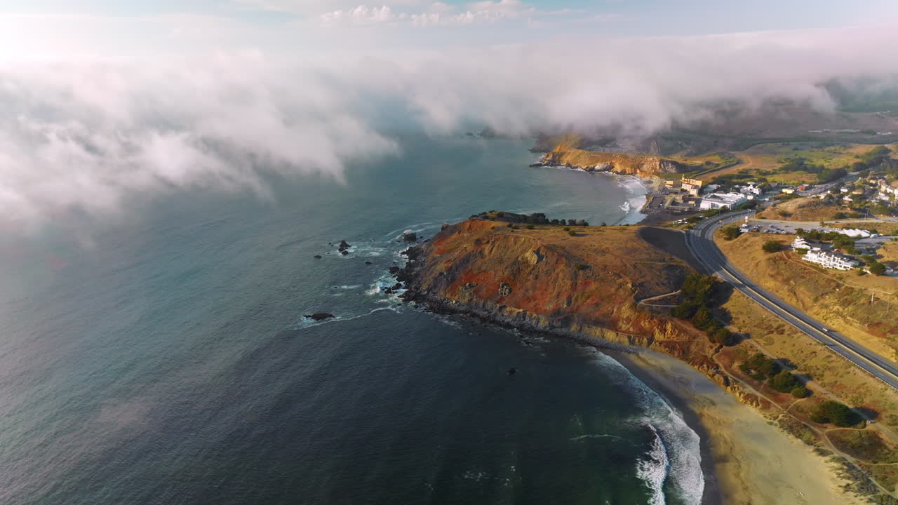 Beautiful rocky coastline of Montara, California, USA. Thick fog slowly moving on city from waters of Pacific. Top view.