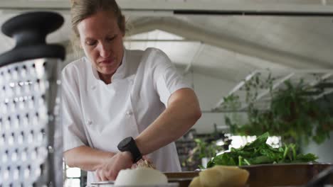 caucasian female chef mixing dough in a bowl