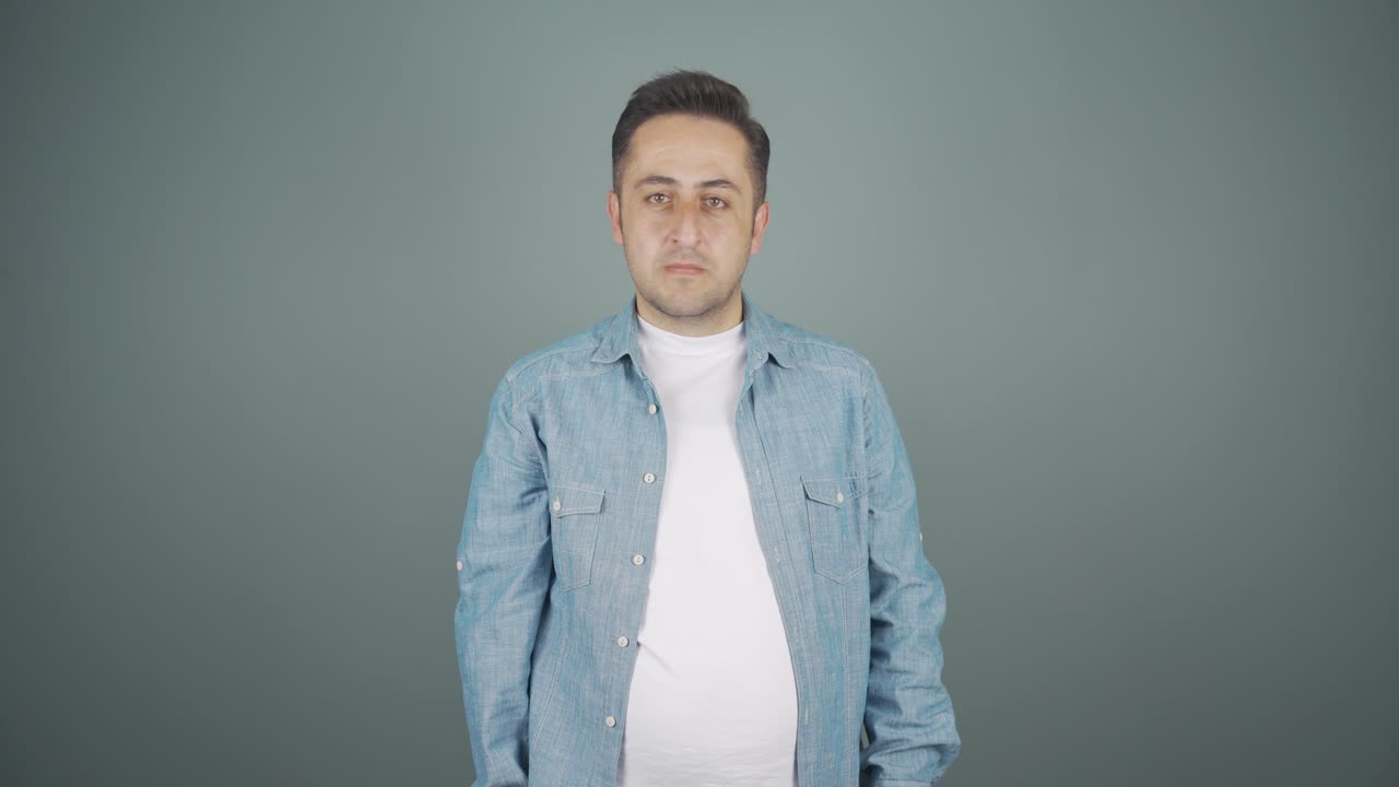 남자가 카메라를 위해 정지 표지판을 만들고 있습니다.