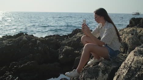 chica tomando una foto en la playa