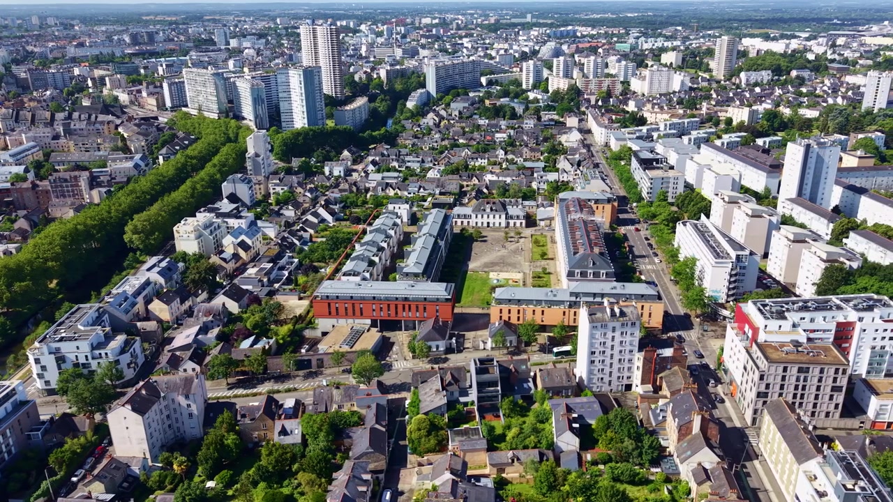 Nedadvendt panorering med droneoversigt over Rennes bybillede med en træallé, der krydser centrum, og den ikoniske beboelsesskyskraber Les Horizons i baggrunden, Ille-et-Vilaine, Bretagne, Frankrig.
