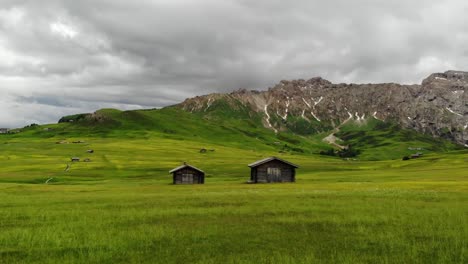 Kamerafahrt-Mit-Der-Drohne-Auf-Der-Seiser-Alm-In-Südtirol-Vorbei-An-Zwei-Almhütten