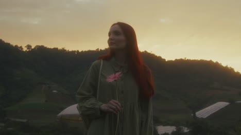 woman with flower at sunset in mountains