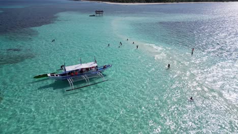 Paralaje-Aéreo-Alrededor-Del-Bote-Estabilizador-De-Banca-En-Balabac-Palawan-Anclado-En-Un-Banco-De-Arena