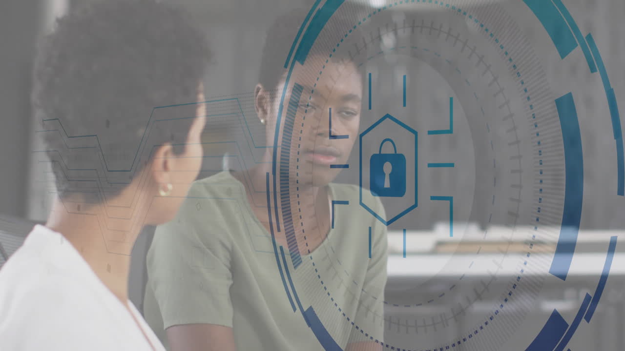 Two colleagues discussing cybersecurity at office desk, featuring floating padlock and interface