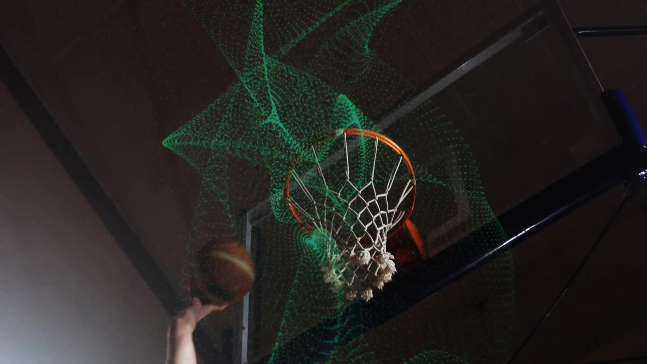 Mano tecnologica sportiva che rilascia un pallone da basket, con il canestro a rete che si deforma e la palla che lo attraversa.
