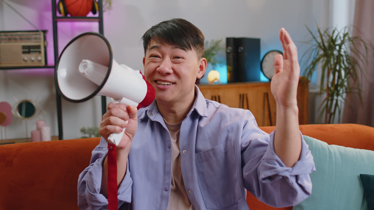 Asian man talking with megaphone proclaiming news loudly announcing advertisement real estate sale