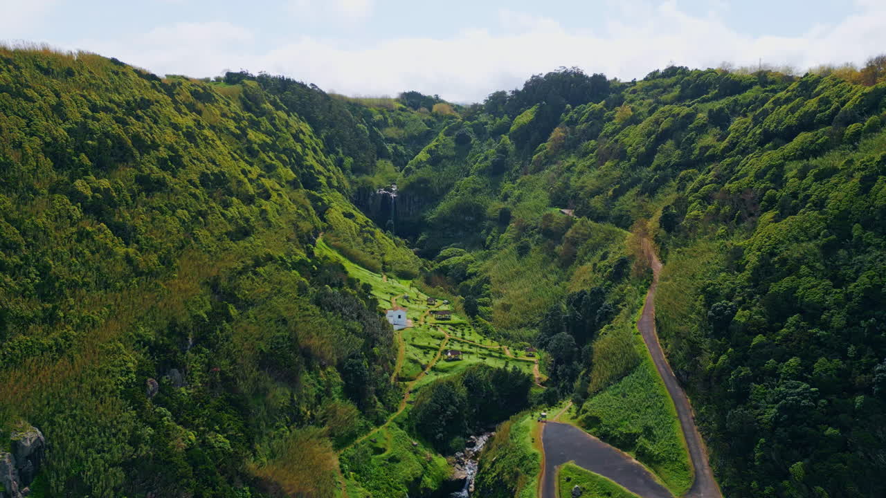 Green forest terrain cloudy summer day. Serpentine road crossing hills landscape