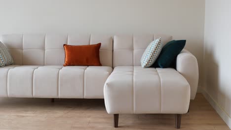 beige sectional sofa with colorful pillows in a modern living room