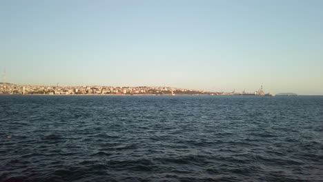 evening, cinematic slow-mo, the view of istanbul camlica from a ferry sailing along the bosphorus