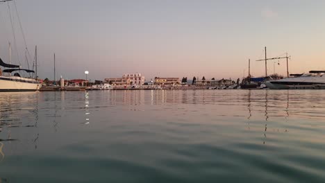 low angle water surface personal perspective of boat returning to port at dusk