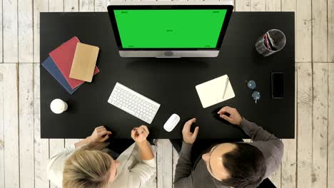 two managers working discussing project on the screen of computer. green screen mock-up display