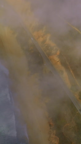 highway passing through the beautiful sandy coast. looking down at the pacific shore through the mist from water. vertical video