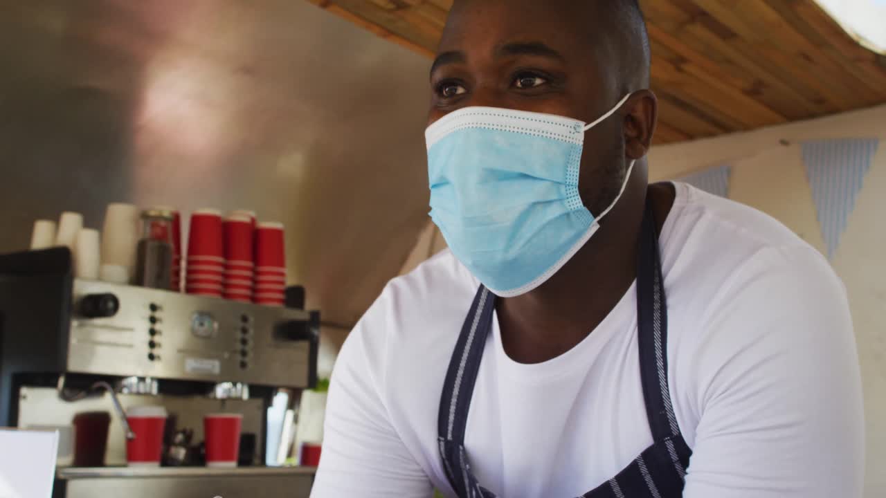 Close up of african american man wearing face mask taking order at the food truck
