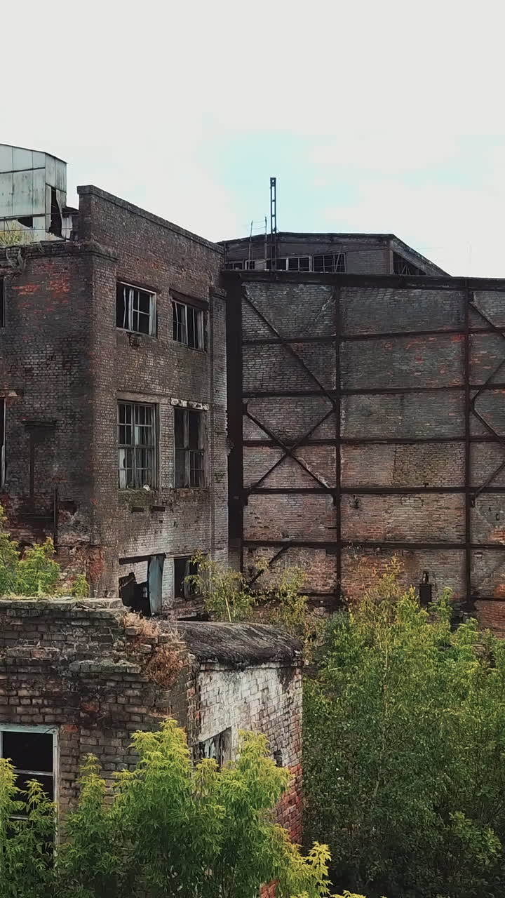 Aerial view from the air to an abandoned factory. Old industrial building for demolition.. Vertical video