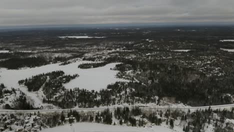 Caminos-De-Hielo-Esparcidos-Por-Todo-El-Lago-Congelado-Escondido-Entre-El-Bosque-Boreal-En-El-Norte-De-Canadá