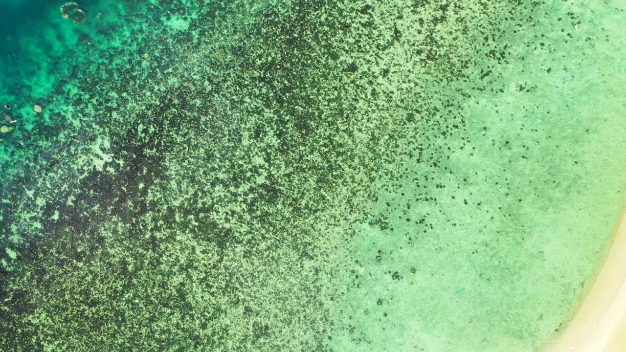 태국 백사장 근처 얕은 청록색 석호의 크리스탈 에메랄드 물 아래 산호초와 바위가 있는 아름다운 바다 질감