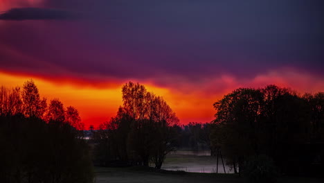 bright red and purple clouds of sunrise on a cold and misty morning