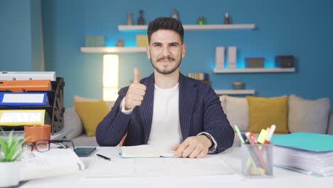 trabajador de oficina en casa mirando a la cámara y haciendo un gesto positivo.