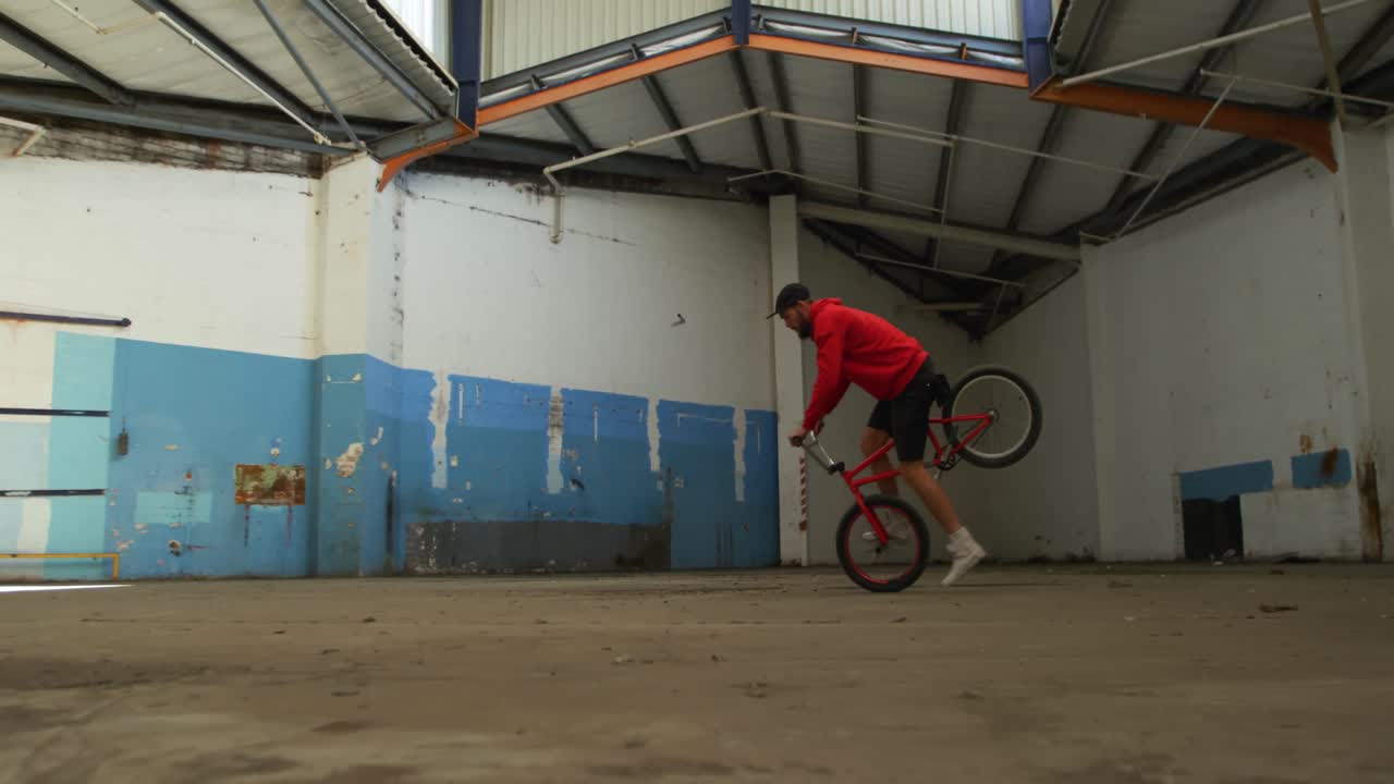 BMX rider in an empty warehouse