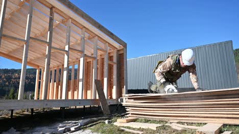 carpintero usando sierra circular para cortar tablero osb para construir una casa de marco de madera.