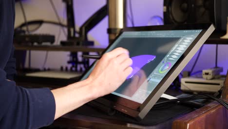 a freelance digital artist or designer sketching and painting in brushstroke with a drawing graphic tablet and pen in an art studio