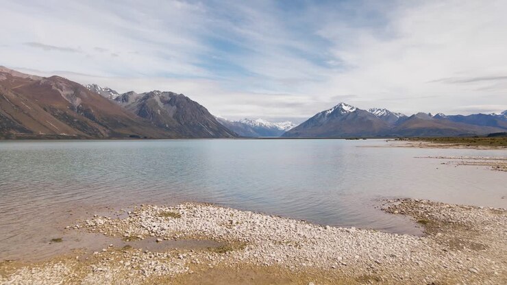 Riprese con drone a bassa quota di un lago glaciale turchese nella Nuova Zelanda assolata.