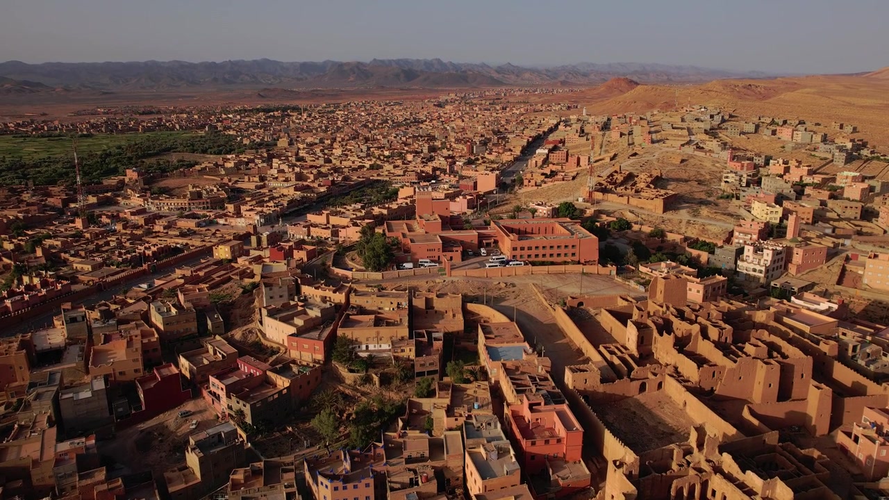 Moschea Mohammed VI e quartieri urbani circostanti a Tinghir, Draa-Tafilalet, Marocco, tra le catene dell'Alto Atlante e del Jbel Saghro, che mostrano l'architettura ksar in terra e un paesaggio semi-arido in espansione.