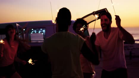 Young-adult-friends-having-fun-on-the-beach-at-night-with-sparklers-4k