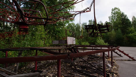 broken swing ride spinning on windy day in pripyat amusement park, zoom in