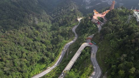 Aerial-pan-shot-of-Genting-highlands-surrounded-by-greenery-and-Chin-Swee-caves-temple-in-Malaysia