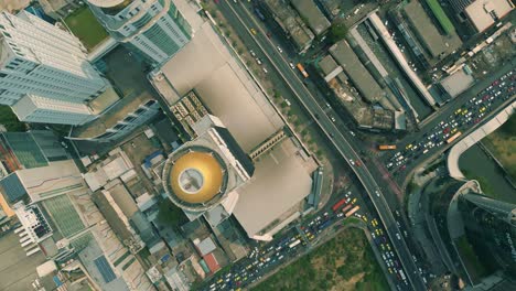 Cinematic-urban-drone-footage-of-an-aerial-smoky-view-flying-over-skyscrapers-and-boulevards-in-the-middle-of-downtown-Bangkok,-Thailand-during-burning-season-looking-down-from-a-bird's-point-of-view