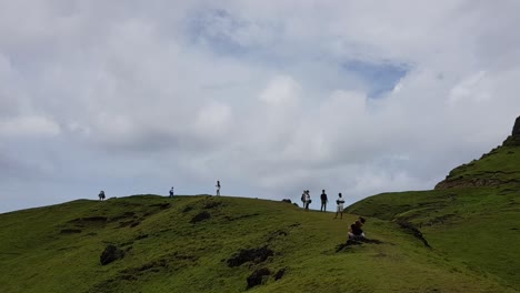 group of tourists walking on top of a hill and taking photos