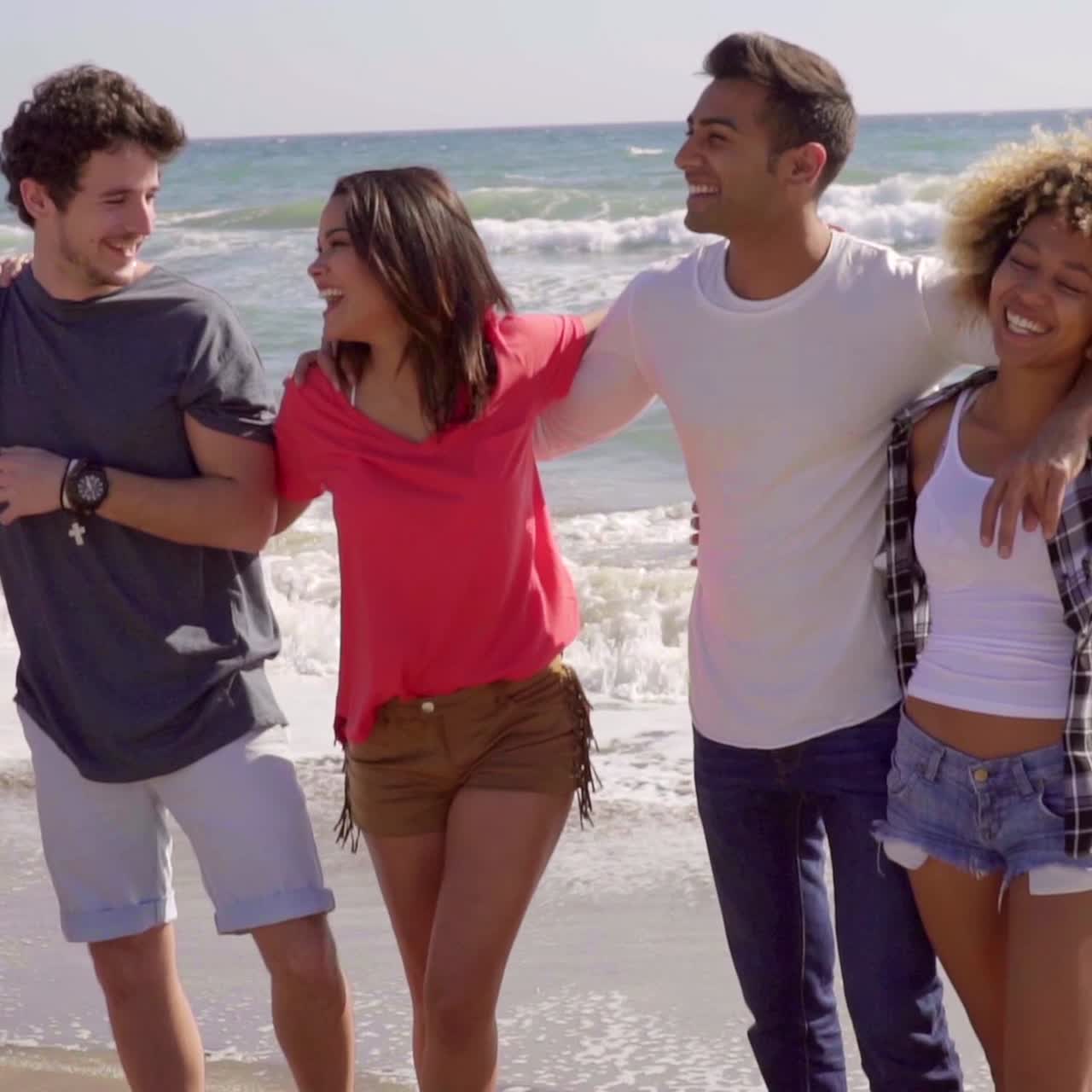 Felice gruppo di amici multirazziali in spiaggia