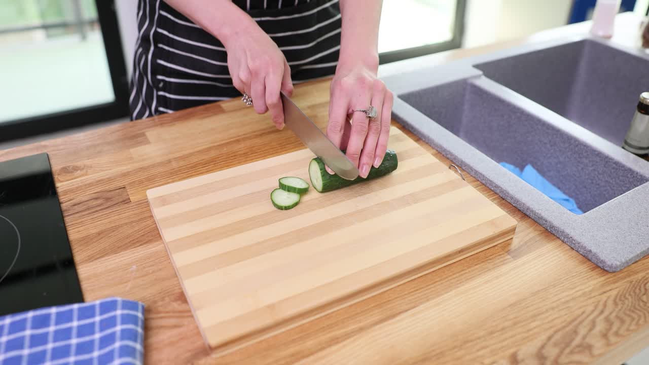 Cutting cucumber in the kitchen