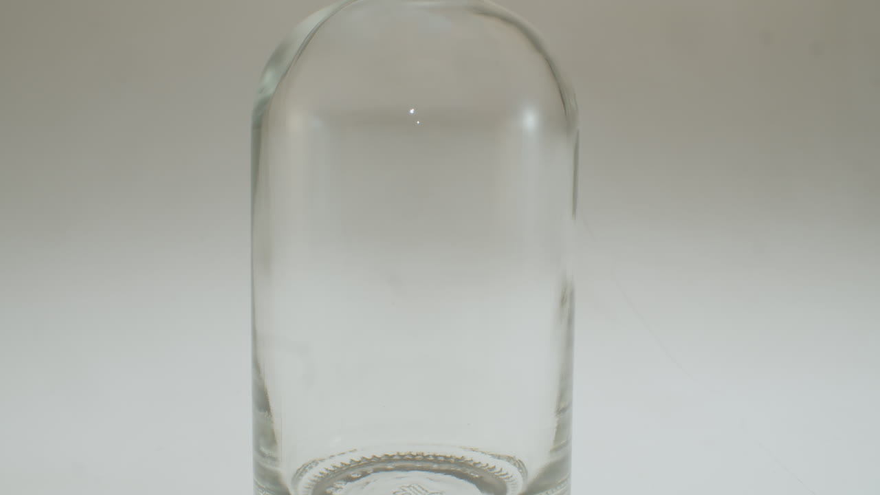 primer plano de verter jugo de manzana en una botella de vidrio