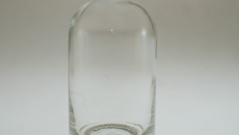 primer plano de verter jugo de manzana en una botella de vidrio