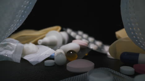 pastillas y medicamentos cerca de máscaras protectoras sobre fondo negro